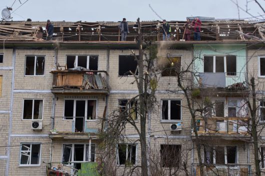 [키이우=AP/뉴시스] 지난 23일(현지 시간) 우크라이나 키이우에서 시청 소속 작업자들이 러시아의 드론 공습을 받은  아파트 건물을 정비하고 있다. 2025.12.27.