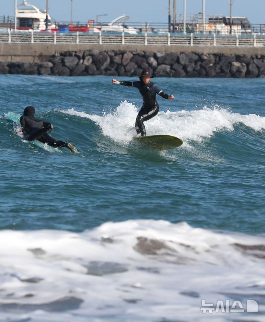 [제주=뉴시스] 우장호 기자 = 모처럼 맑은 날씨를 보인 6일 오전 제주시 이호테우해수욕장에서 레저객들이 서핑을 하고 있다. 2026.01.07. woo1223@newsis.com