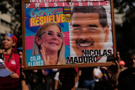 [카라카스=AP/뉴시스] 6일(현지 시간) 베네수엘라 카라카스에서 미국에 의해 체포된 니콜라스 마두로 대통령 부부의 귀환을 요구하는 행진이 열린 가운데, 한 지지자가 마두로 대통령 부부의 사진을 들고 있다. 2026.01.07.