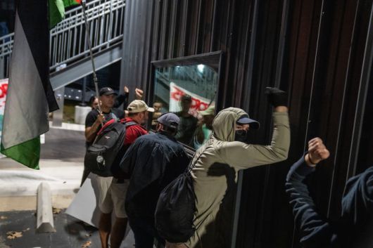 [플루거빌=AP/뉴시스] 8일(현지 시간) 미 텍사스주 플루거빌에서 전날 미네소타주 미니애폴리스에서 이민세관단속국(ICE) 요원의 총격으로 사망한 르네 니콜 굿 사건에 항의하는 시위대가 현지 ICE 시설 벽을 두드리며 철수를 요구하고 있다.