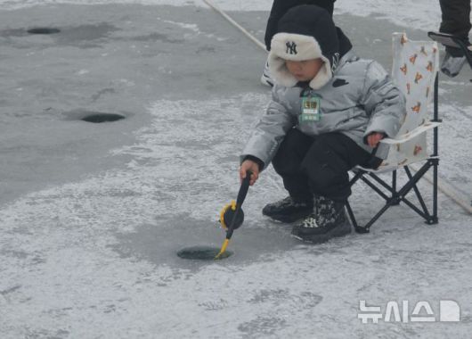 [화천=뉴시스]서백 기자=주말을 맞은 11일 화천산천어축제장을 찾은 한 아이가 산천어를 잡아 기뻐하고 있다. 2026.1.11. syi23@newsis.com