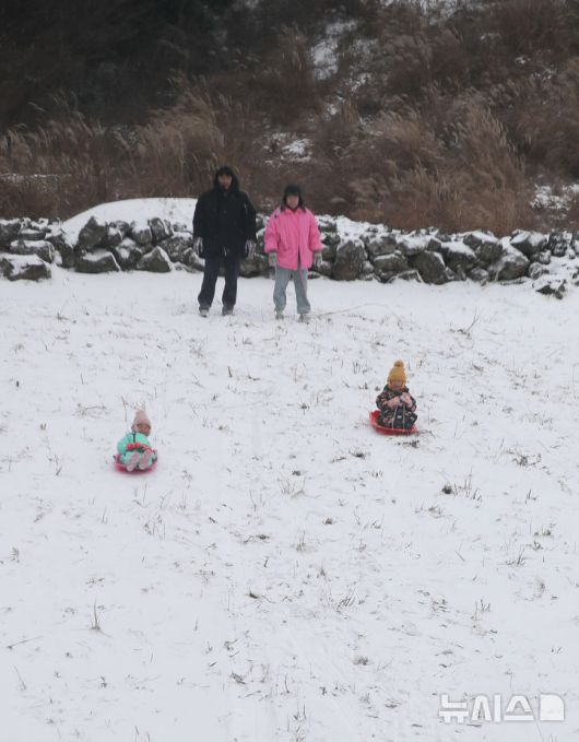 [제주=뉴시스] 우장호 기자 = 제주 산지·중산간·동부·남부에 대설특보가 내려진 11일 오전 제주시 어승생 삼거리 입구 인근 오름에서 어린이들이 썰매를 타고 있다.기상청에 따르면 제주도는 12일까지 한라산 등 고지대를 중심으로 최대 15㎝의 눈이 내려 쌓일 것으로 예측됐다. 2026.01.11. woo1223@newsis.com