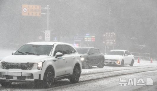[제주=뉴시스] 우장호 기자 = 제주 산지·중산간·동부·남부에 대설특보가 내려진 11일 오전 제주시 어승생 삼거리 입구에서 제주서부경찰서 소속 경찰관이 도로통제를 하고 있다. 기상청에 따르면 제주도는 12일까지 한라산 등 고지대를 중심으로 최대 15㎝의 눈이 내려 쌓일 것으로 예측됐다. 2026.01.11. woo1223@newsis.com