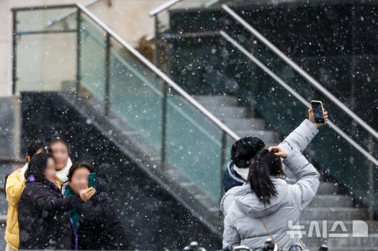 [서울=뉴시스] 정병혁 기자 = 12일 서울 영등포구 영등포역 앞에서 시민들이 눈을 함께 사진을 찍고 있다. 2026.01.12. jhope@newsis.com