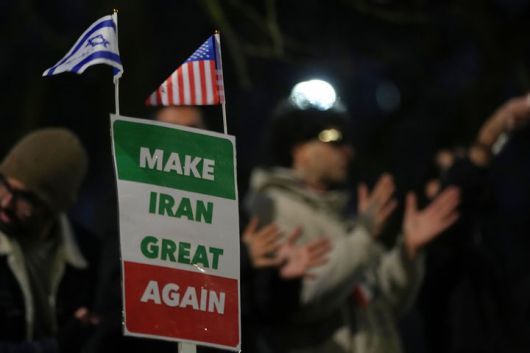 [런던=AP/뉴시스] 지난 12일(현지 시간) 영국 런던의 이란 대사관 밖에서 시위대가 "이란을 다시 위대하게'(MIGA)라고 적힌 손팻말을 들고 있다. 2026.01.14.