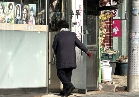 [서울=뉴시스] 한민아 인턴기자= 한 손님이 오래된 미용실 문을 열고 들어가고 있다. 2026.01.13.  *재판매 및 DB 금지