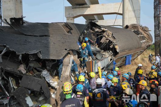 [시키오=AP/뉴시스] 14일(현지 시간) 태국 나콘랏차시마주 시키오 고속철 공사장 크레인이 여객 열차로 추락한 현장에서 구조대가 열차 잔해를 수습하고 있다. 2026.01.15.
