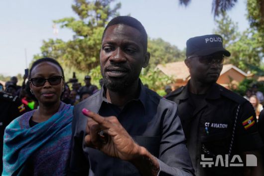 [AP/뉴시스] 가수 출신으로 무세베니에 연속 도전하고 있는 바비 와인이 15일 수도 캄팔라에서 대선 투표를 마치고 잉크 묻은 손가락을 들어보이고 있다