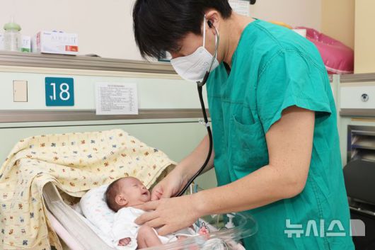 [서울=뉴시스] 서울아산병원은 심장 크기가 엄지손가락만한 저체중아의 복잡한 선천성심장병을 생후 8일 만에 치료하는 데 성공했다. 사진은 정의석 서울아산병원 신생아과 교수가 지난 2일 수술 후 신생아 중환자실에서 집중치료를 받고 있는 이준이를 진찰하고 있는 모습. (사진= 서울아산병원 제공)