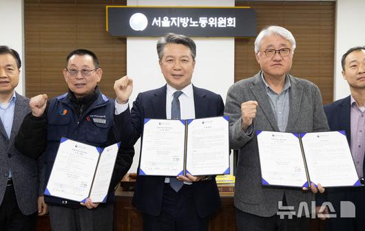 [서울=뉴시스] 황준선 기자 = 지난 14일 밤 서울 영등포구 서울지방노동위원회에서 열린 특별조정위원회 2차 사후 조정회의에서 교섭을 타결한 박점곤 전국자동차노동조합연맹 서울시버스노동조합 위원장과 김정환 서울시버스운송사업조합 이사장이 조정안을 들고 위원들과 기념촬영 하고 있다. 2026.01.15. hwang@newsis.com