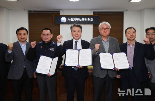 [서울=뉴시스] 황준선 기자 = 지난 14일 밤 서울 영등포구 서울지방노동위원회에서 열린 특별조정위원회 2차 사후 조정회의에서 교섭을 타결한 박점곤 전국자동차노동조합연맹 서울시버스노동조합 위원장과 김정환 서울시버스운송사업조합 이사장이 조정안을 들고 위원들과 기념촬영 하고 있다. 2026.01.15. hwang@newsis.com