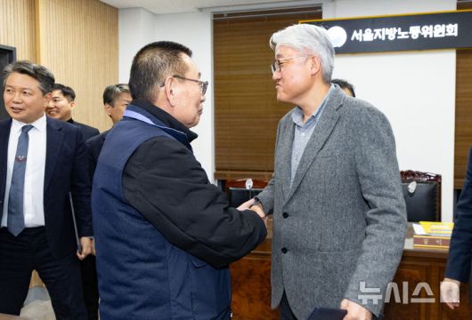[서울=뉴시스] 황준선 기자 = 지난 14일 밤 서울 영등포구 서울지방노동위원회에서 열린 특별조정위원회 2차 사후 조정회의에서 교섭을 타결한 박점곤 전국자동차노동조합연맹 서울시버스노동조합 위원장과 김정환 서울시버스운송사업조합 이사장이 악수하고 있다. 2026.01.15. hwang@newsis.com