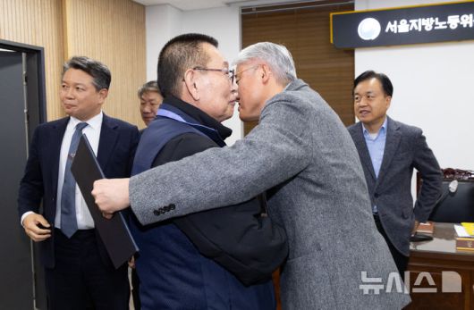 [서울=뉴시스] 황준선 기자 = 지난 14일 밤 서울 영등포구 서울지방노동위원회에서 열린 특별조정위원회 2차 사후 조정회의에서 교섭을 타결한 박점곤 전국자동차노동조합연맹 서울시버스노동조합 위원장과 김정환 서울시버스운송사업조합 이사장이 포옹하고 있다. 2026.01.15. hwang@newsis.com