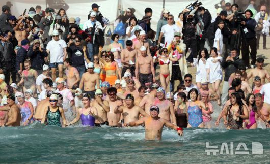 [부산=뉴시스] 하경민 기자 = '제39회 해운대 북극곰축제'가 열린 18일 부산 해운대구 해운대해수욕장에서 시민과 관광객 등 인간 북극곰들이 일제히 차가운 겨울바다에 뛰어들고 있다. 2026.01.18. yulnetphoto@newsis.com