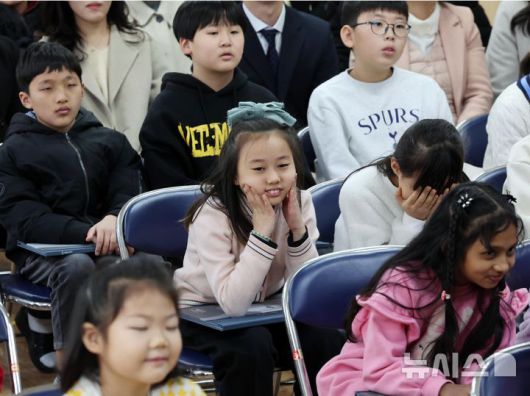 [부산=뉴시스] 하경민 기자 = 부산 사상구 괘법초등학교가 저출산, 학령인구 감소 등으로 인근 학교와 통·폐합이 확정된 가운데 20일 학교 강당에서 열린 이별식에 참석한 학생들이 추억의영상을 함께 시청하고 있다.  1982년 3월5일 28학급(학생 1261명)으로 개교한 괘법초는 지난해 전교생 52명의 소규모 학교로 운영, 인근 감전초등학교와 통·폐합이 확정됐다. 괘법초를 비롯해 올해 부산에서 통·폐합되는 초등학교는 영도구 봉삼초 및 신선초 등 총 3곳이다. 2026.01.20. yulnetphoto@newsis.com