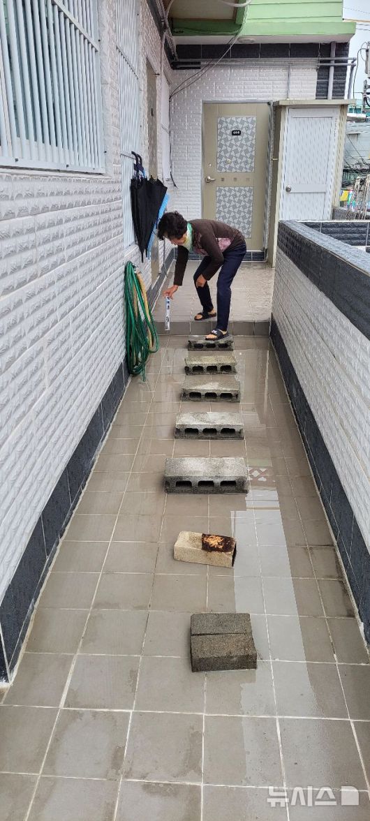 [부산=뉴시스] 진민현 기자 = 지반 침하로 2층 주택 바닥이 기울면서 물이 고여, 사상~하단선 공사 인근 주민이 바닥에 놓인 돌과 블록을 디디며 이동하고 있다. 2026.01.19. truth@newsis.com