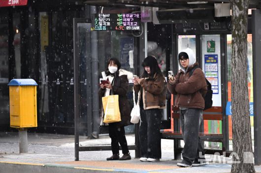 [광주=뉴시스] 이영주 기자 = 광주지역에 최대 5㎝ 적설량이 예보된 21일 오전 광주 북구 오치동 한 버스정류장에서 시민들이 눈을 피하며 시내버스를 기다리고 있다. 2026.01.21. leeyj2578@newsis.com