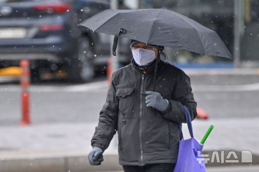 [광주=뉴시스] 이영주 기자 = 광주지역에 최대 5㎝ 적설량이 예보된 21일 오전 광주 북구 오치동 한 횡단보도에서 시민이 걸음을 재촉하고 있다. 2026.01.21. leeyj2578@newsis.com