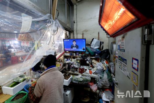 [서울=뉴시스] 김진아 기자 = 21일 서울 서대문구 인왕시장의 한 상점에 이재명 대통령의 신년 기자회견이 TV를 통해 생중계 되고 있다. 2026.01.21. bluesoda@newsis.com