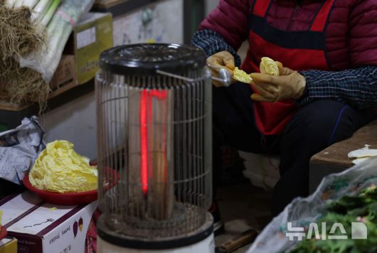 [서울=뉴시스] 김진아 기자 = 한파가 계속되고 있는 21일 서울 서대문구 인왕시장에서 상인들이 난로를 켜놓고 있다. 2026.01.21. bluesoda@newsis.com