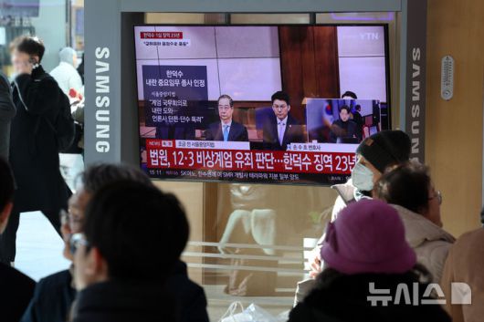 [서울=뉴시스] 조성우 기자 = 한덕수 전 국무총리의 내란 우두머리 방조, 내란 중요임무 종사 혐의 사건 1심 선고 재판이 열린 21일 오후 서울역 대합실에서 시민들이 한 전 총리의 1심 징역 23년 선고 관련 뉴스를 시청하고 있다. 2026.01.21. xconfind@newsis.com