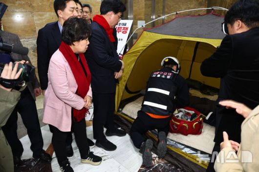 [서울=뉴시스] 김명년 기자 = 소방 구급대원이 21일 국회 로텐더홀 장동혁 국민의힘 대표 통일교·공천헌금 '쌍특검' 수용 촉구 단식 농성장에서 장 대표 상태를 확인하고 있다. 2026.01.21. kmn@newsis.com