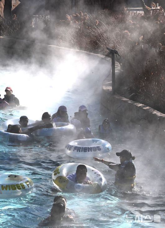 [용인=뉴시스] 김종택 기자 = 전국적으로 매서운 한파가 이어지고 있는 22일 경기 용인시 캐리비안 베이를 찾은 시민들이 수증기가 피어 오르는 야외 유수풀에서 즐거운 시간을 보내고 있다. 2026.01.22. jtk@newsis.com