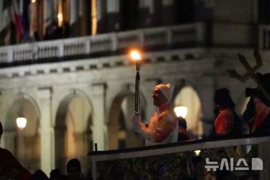 [베네치아=AP/뉴시스] 22일(현지 시간) 이탈리아 베네치아에서 2026 밀라노·코르티나담페초 동계올림픽 성화 봉송이 진행되고 있다. 2026.01.23.