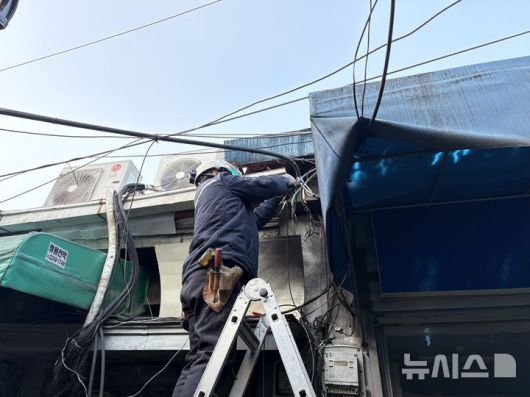 [서울=뉴시스]신유림 기자=지난 19일 오후 서울 중구 인현시장에 노후 전선에서 스파크가 튀어 한국전력공사 직원이 수리하고 있다. 2026.01.23. spicy@newsis.com