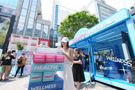 서울 명동 명동예술극장 앞 2025 코리안뷰티페스티벌 웰컴센터에서 외국인 관광객들이 체험하고 있다. [사진=한국방문의해위원회]