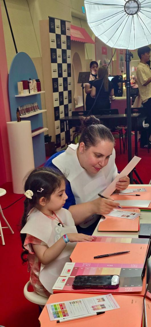 19일 서울 동대문 동대문디자인플라자(DDP)에서 열린 2025 코리안뷰티페스티벌 K-뷰티 타운에서 미국인 관광객 로라 모녀가 퍼스널 컬러 분석 체험을 하고 있다. [사진=기수정 기자]