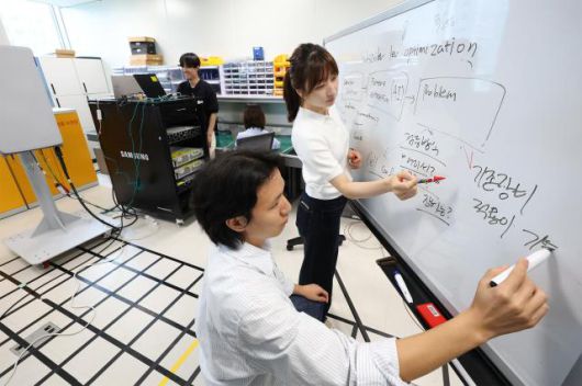 KT-삼성리서치 공동 연구팀이 무선망 최적화 기술 개발을 논의하는 모습 사진=KT