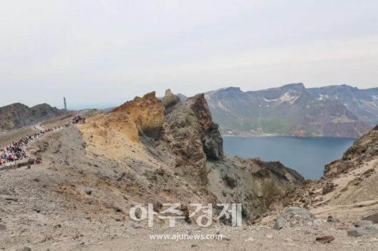 6월 27일 백두산 정상(북파)에 위치한 크기를 가늠하기 어려운 기암괴석 옆으로 사람들이 걸어다닌다. AJP 한준구 사진기자