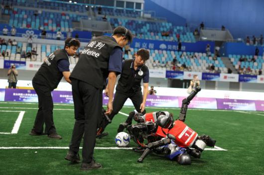16일 중국 베이징  스피드 스케이팅 경기장에서 열린 제1회 세계 휴머노이드 로봇 운동회에서 여린 5대5 축구 조별경기에서 심판들이 충돌해 넘어진 로봇선수들을 바라보고 있다. [사진=로이터연합뉴스]