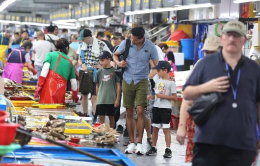 지난 8월 21일 부산 중구 자갈치시장을 찾은 외국인 관광객들이 시장을 둘러보며 수산물을 고르고 있다. [사진=연합뉴스]