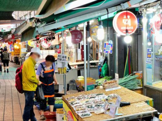 서울 송파구 마천중앙시장에서 한 손님이 떡을 구매하는 모습 [사진=홍승완 기자]