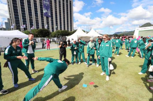 한국관광공사 오징어 게임 핑크가드와 함께하는 여행 이벤트에서 참가자들이 조별 미션인 딱지치기를 즐기고 있다. [사진=한국관광공사]