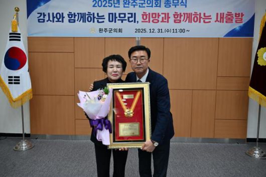 이경애 완주군의원(왼쪽)이 유의식 의장우루보터 전북 지방의정봉사상을 전수받고 있다.[사진=완주군의회]