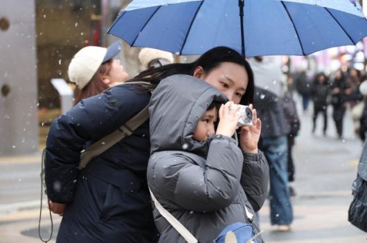 Tourists enjoy heavy snowfall in Myeong-dong, central Seoul, on Jan. 12, 2026. AJP Yoo Na-hyun
