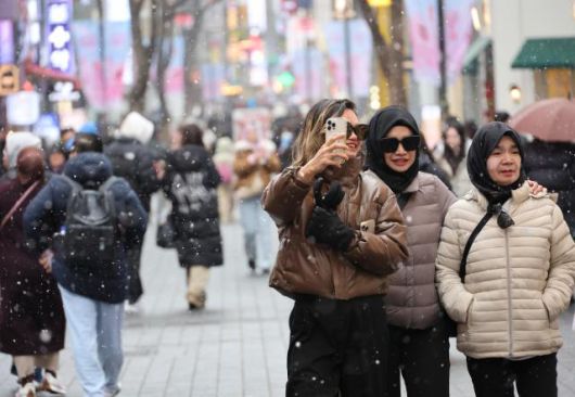 Tourists enjoy heavy snowfall in Myeong-dong, central Seoul, on Jan. 12, 2026. AJP Yoo Na-hyun