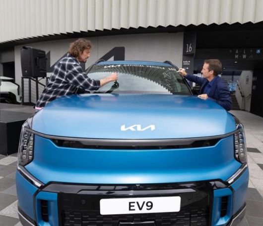 대회공식차량 중 EV9에 사인하고 있는 러시아 테니스 레전드 마라트 사핀과 호주 경마 레전드이자 기아 호주법인 앰버서더 데이미언 올리버 [사진=현대차]