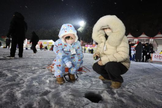 Visitors try ice fishing at night at the Hwacheon Sancheoneo Ice Festival in Hwacheon, Gangwon Province. Jan. 12, 2026. AJP Han Jun-gu