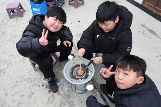 Children make dalgona (sugar candy) at a traditional game experience area at the Hwacheon Sancheoneo Ice Festival in Hwacheon, Gangwon Province. Jan. 12, 2026. AJP Han Jun-gu