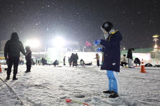 A child tries ice fishing at night at the Hwacheon Sancheoneo Ice Festival in Hwacheon, Gangwon Province. Jan. 12, 2026. AJP Han Jun-gu