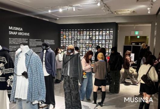 ‘무신사 도쿄 팝업 스토어 2025’ 스냅 아카이브 존을 둘러보는 방문객들 [사진=무신사]