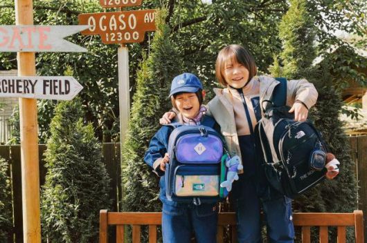 ‘2026 노스페이스 신학기 키즈 가방’을 든 홍보대사 신우(왼쪽)와 이준 [사진=영원아웃도어]