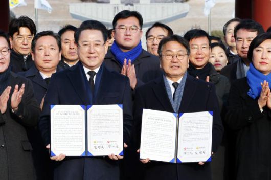 Gwangju Mayor Kang Gi-jung and South Jeolla Province Governor Kim Yung-rok pose for a commemorative photo after announcing the Gwangju–South Jeolla administrative integration declaration at the May 18th National Cemetery in Buk-gu, Gwangju, on Jan. 2, 2026. Yonhap