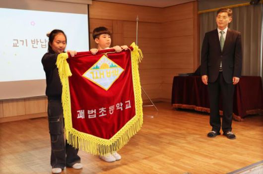 Students return the school flag during a farewell ceremony at Gwabeop Elementary School in Sasang-gu, Busan, on Jan. 20. Yonhap