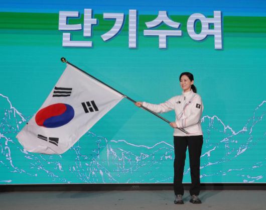 Lee Soo-kyung, head of South Korea’s national delegation, waves the national flag during a send-off ceremony for the 2026 Milan Winter Olympics at Olympic Parktel in Songpa-gu, Seoul, on Jan. 2, 2026. Yonhap