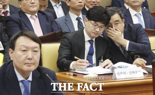 한동훈(가운데) 대검찰청 반부패강력부장이 지난해 10월17일 서울 서초구 대검찰청에서 열린 국회 법제사법위원회의 대검찰청 2019 국정감사에서 백혜련 더불어민주당 의원의 질의에 답변 뒤 조상준(오른쪽) 형사부장과 귀엣말 나누고 있다./뉴시스